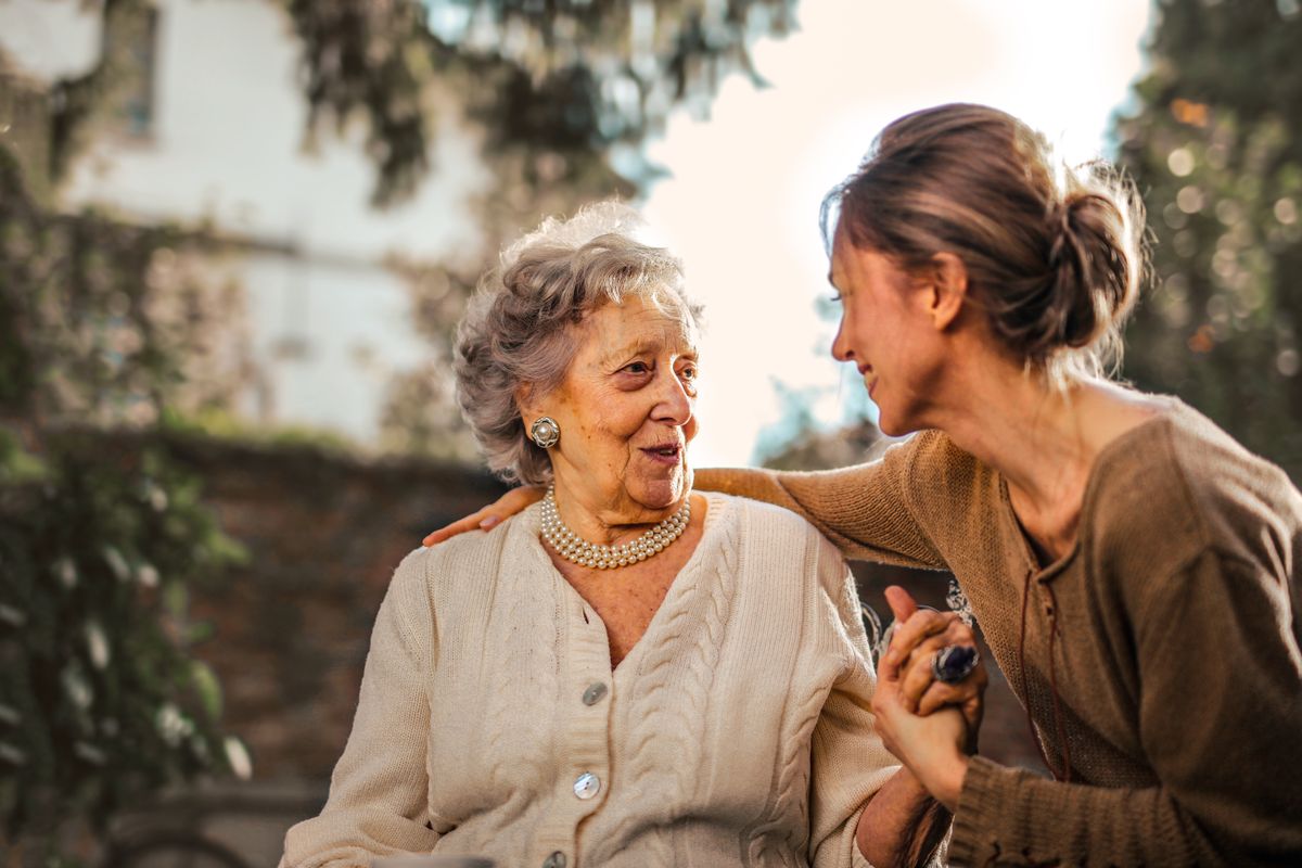 An older woman laughing with her companion over coffee